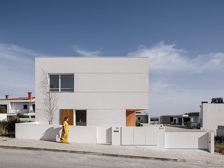 Modern, minimalist residential building with clean lines, large windows, and wooden accents.