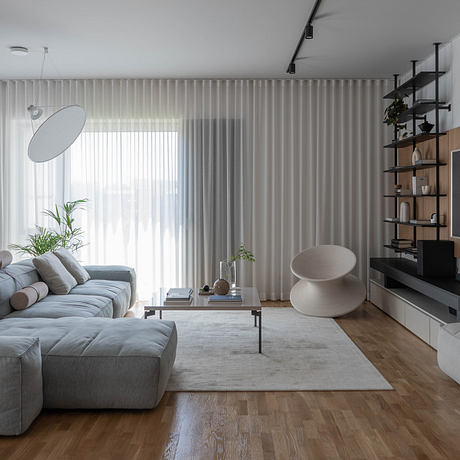 Modern living room with sleek furniture, minimalist shelving, and large windows providing ample natural light.