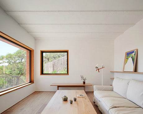 Bright and airy living room with large windows framing the natural landscape.