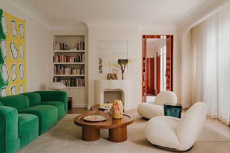 A cozy, modern living room with a green sofa, wooden coffee table, and built-in bookshelf.