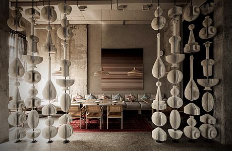 A uniquely designed dining space with an array of intricate paper lanterns suspended from the ceiling, creating a captivating and visually striking ambiance.