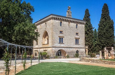 A stately stone palace with intricate arched windows and a distinctive rooftop tower.