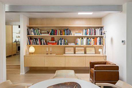 Spacious living room with built-in bookshelves, wooden furniture, and warm lighting.