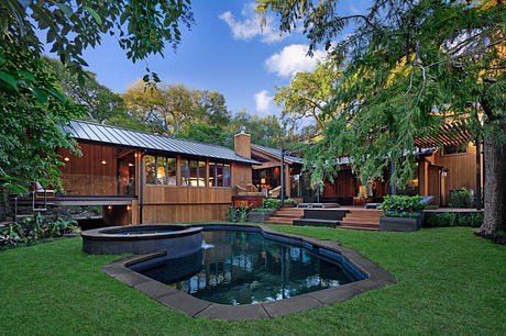 Rustic wooden structures with a serene pool and lush greenery surrounding the property.