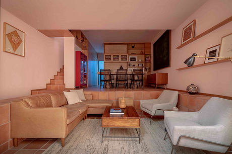 Warm-toned living room with modern furniture, built-in shelving, and tiled floor steps.