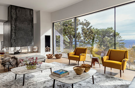 Stunning modern living room with large windows, sleek fireplace, and stylish furnishings.