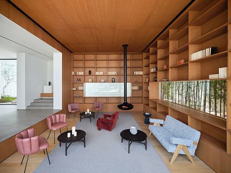 A cozy and modern living space with a wood-paneled ceiling, built-in shelving, and vibrant seating.