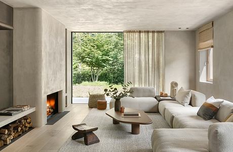 Minimalist living room with large window, cozy fireplace, and natural textures.