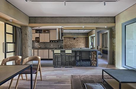 Modern loft kitchen with exposed brick walls, wood floors, and minimal furnishings.