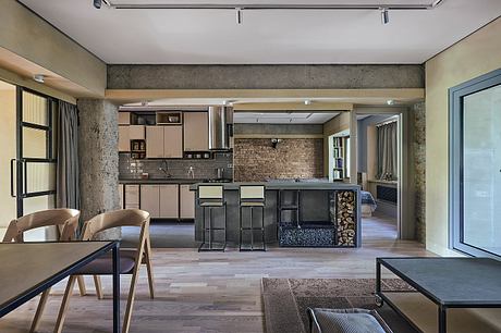 Modern loft kitchen with exposed brick walls, wood floors, and minimal furnishings.