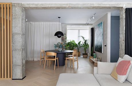 Modern, minimalist living room with wood furniture, plants, and neutral color palette.