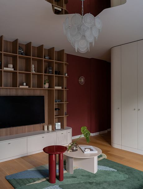 A modern living room with a wooden entertainment unit, statement chandeliers, and a minimalist coffee table.