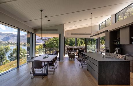 An open-concept kitchen and dining area with floor-to-ceiling windows offering stunning lake views.