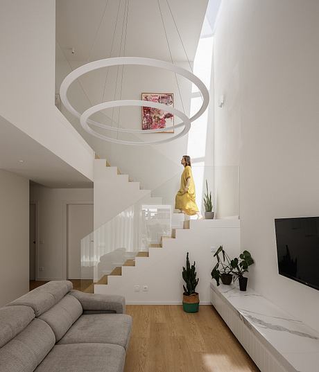 Sleek, minimalist interior with modern floating stairs, circular light fixtures, and plants.