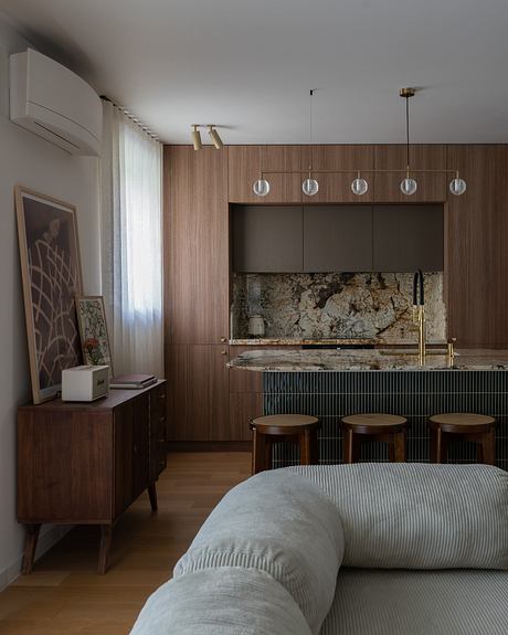 A modern kitchen with wood paneling, pendant lighting, and a granite countertop.