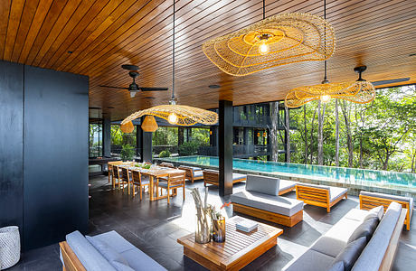 Luxurious open-concept living space with modern furnishings, pool, and elaborate lighting.