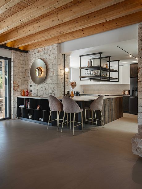 Rustic kitchen with exposed stone walls, wooden beams, and modern industrial shelving.