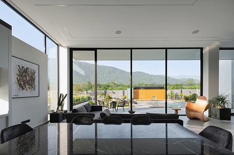 Expansive living space with sleek, minimalist furnishings and panoramic mountain views.