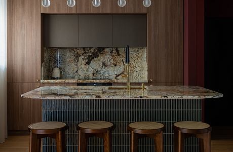 Sleek modern kitchen with granite countertops, wood paneling, and pendant lighting.