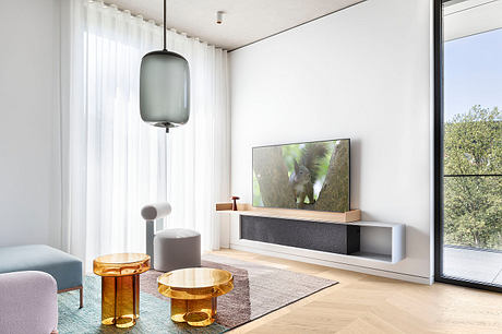 Sleek, modern living room with large window, TV unit, and amber-toned side tables.