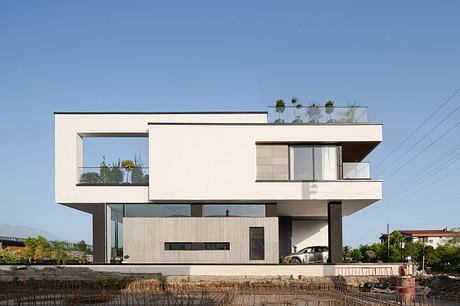Modern, minimalist residential home with clean lines, large windows, and suspended balconies.