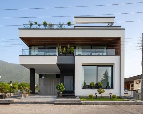 Modern multi-story building with sleek design, glass walls, wood accents, and landscaped balconies.