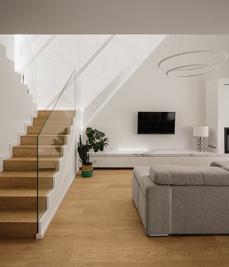 Modern living room with white walls, wooden stairs, and sleek furniture.