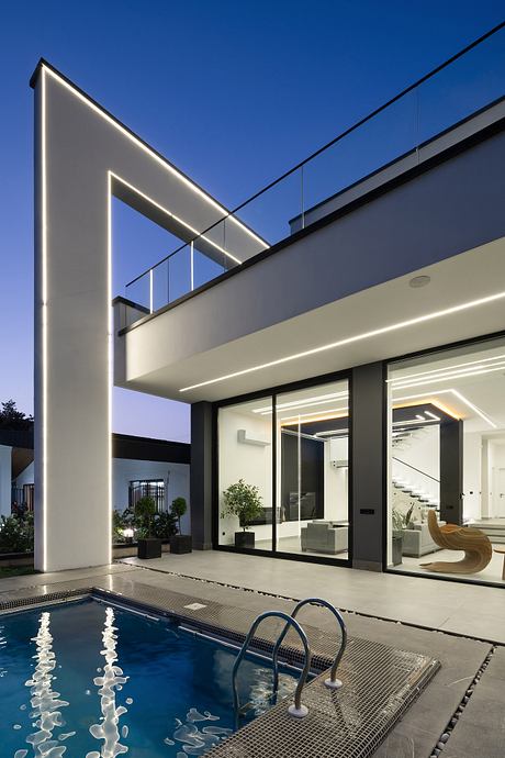 Modern home with sleek architectural features, glass walls, and a swimming pool.