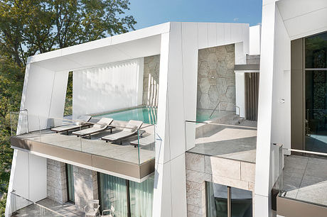 A modern, geometric architecture with an outdoor pool and lounge area.