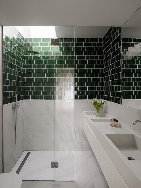 A modern bathroom with a seamless glass shower and a striking monochrome tile wall.
