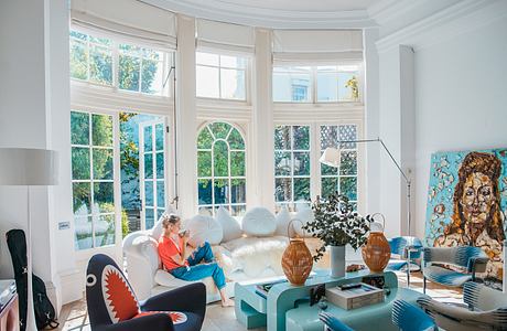 Elegant, light-filled living room with arched windows and cozy seating arrangements.