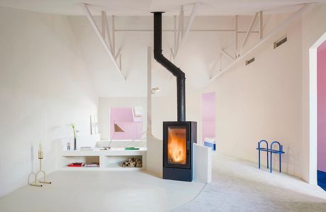 Minimalist, modern living space with wood-burning stove, white walls, and geometric accents.