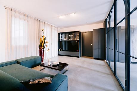 Spacious living room with minimalist furniture, built-in cabinets, and floor-to-ceiling windows.