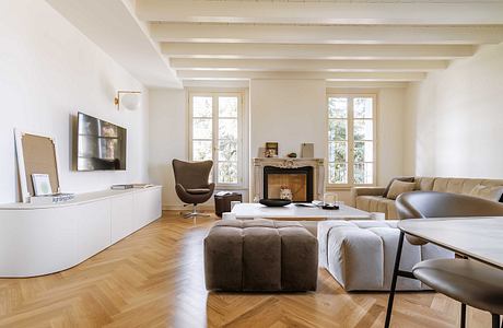 Bright, spacious living room with high ceilings, wooden floors, and fireplace.