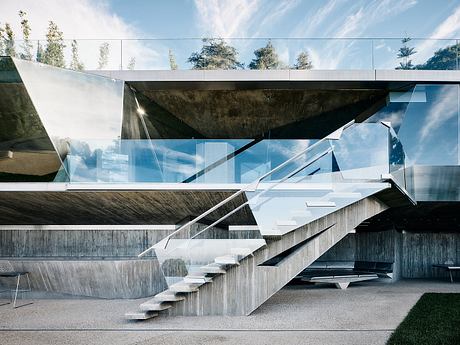 Striking concrete and glass architectural structure with dramatic geometric stairs.