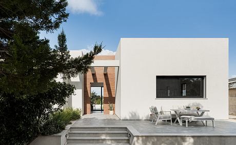 Contemporary residential building with clean lines, exterior steps, and covered patio area.