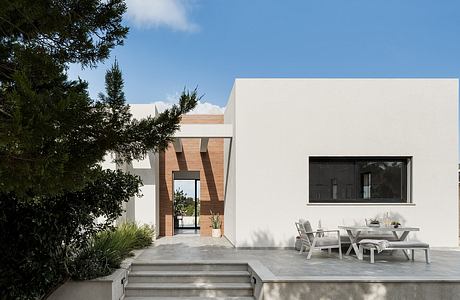 Contemporary residential building with clean lines, exterior steps, and covered patio area.