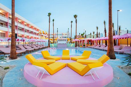 Vibrant pool area with vivid colors, inviting loungers, and tropical palm trees.