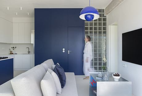 A modern apartment interior with sleek cabinetry, blue accent walls, and contemporary lighting.