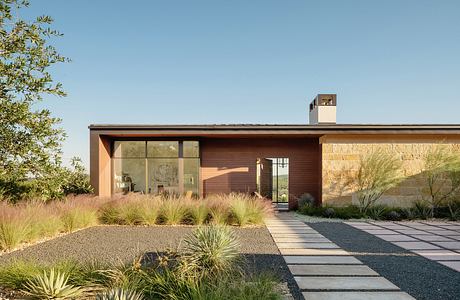 Contemporary single-story home with large windows, wooden siding, and minimal landscaping.