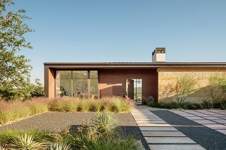 Contemporary single-story home with large windows, wooden siding, and minimal landscaping.