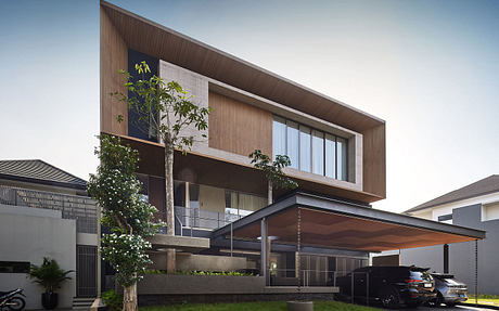 A modern two-story home with a wooden exterior, large windows, and a covered patio.