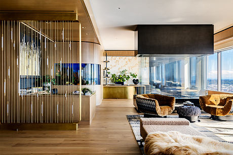 Stunning modern interior with sleek glass walls, warm wood tones, and plush furnishings.