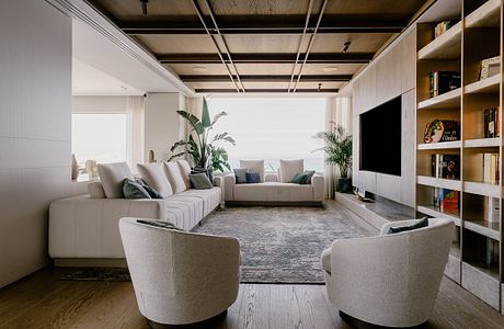 Large open-concept living room with modern furniture, shelving, and natural lighting.