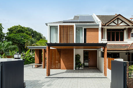 Modern home with wood-paneled facade, solar panels, and lush greenery surroundings.