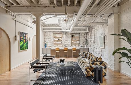 Eclectic loft space with exposed brick walls, wooden beams, and modern furnishings.