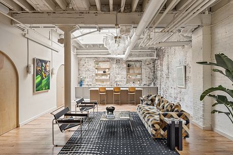 Eclectic loft space with exposed brick walls, wooden beams, and modern furnishings.