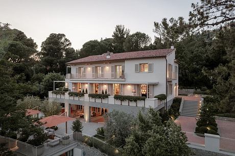 Elegant multi-level villa with inviting balconies, outdoor seating, and lush greenery.