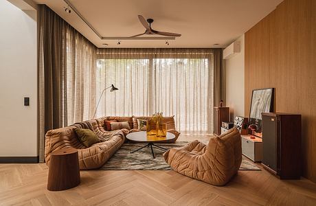 Cozy living room with tufted leather seating, wood paneling, and a circular coffee table.