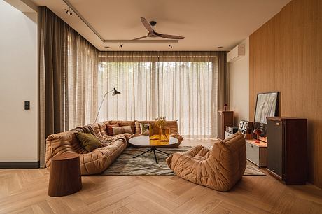 Cozy living room with tufted leather seating, wood paneling, and a circular coffee table.